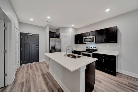 a kitchen with black cabinets and a white counter top