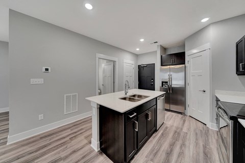 a kitchen with a large island and a stainless steel refrigerator