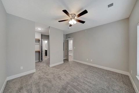 the living room is empty and has a ceiling fan