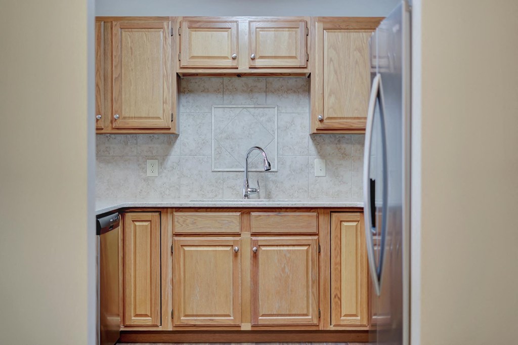 a kitchen with wooden cabinets and a refrigerator