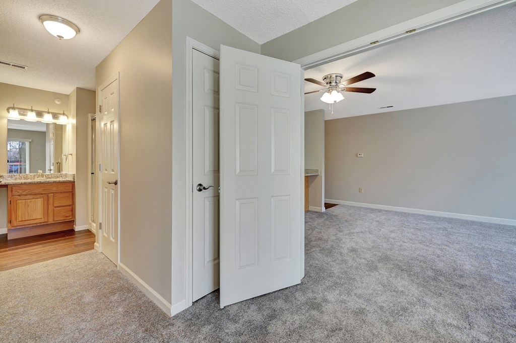 an empty living room with an open door to a bathroom