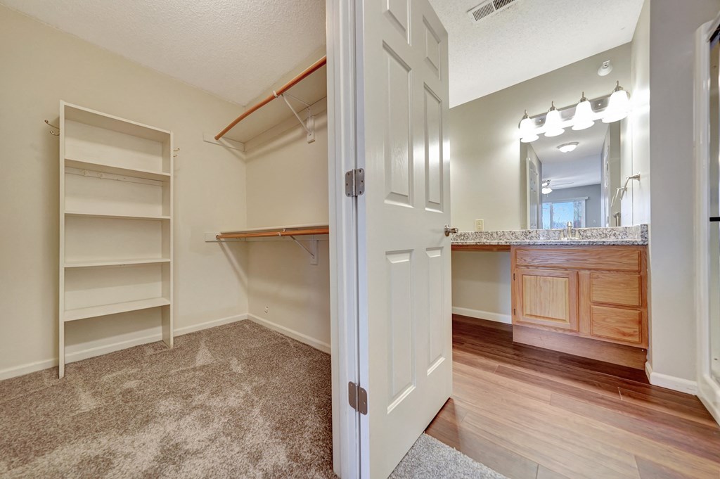 a bedroom with a closet and a bathroom with shelves