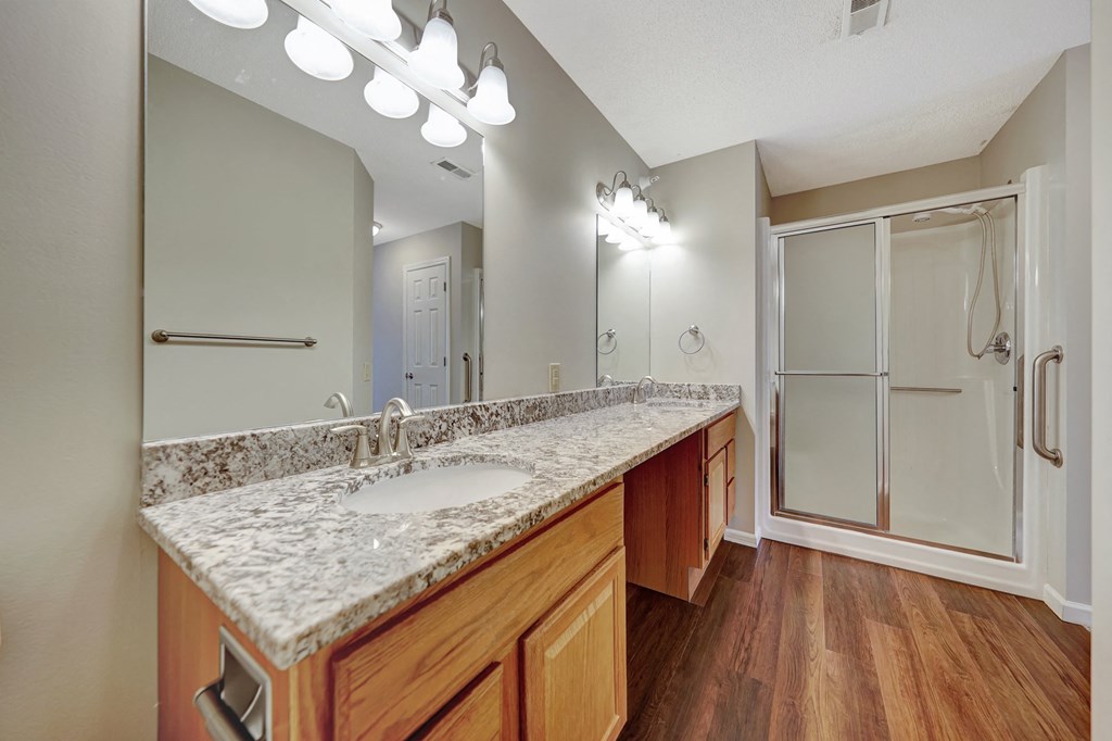 a bathroom with a glass counter top and a shower
