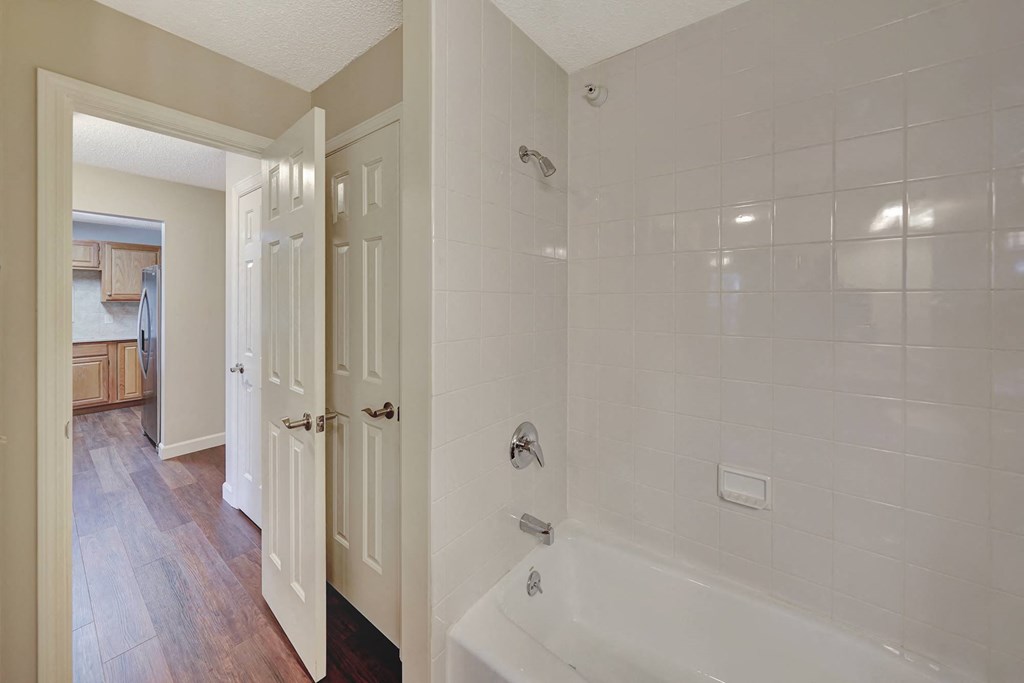 a white bathroom with a tub and a shower