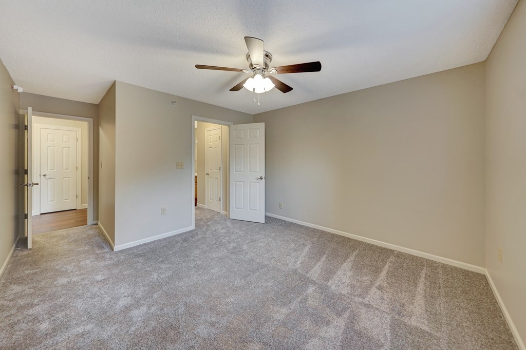 an empty living room with a ceiling fan