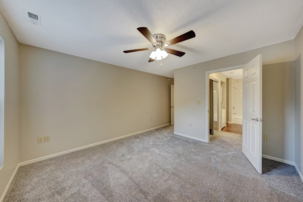an empty living room with a ceiling fan