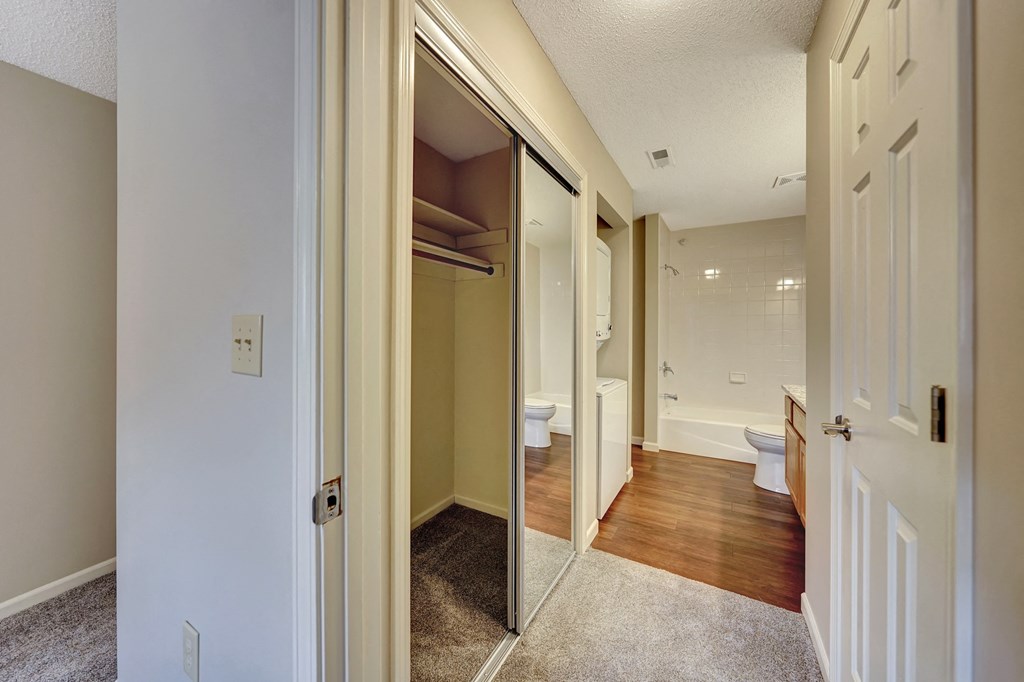 the entry to a bathroom with a mirrored closet door