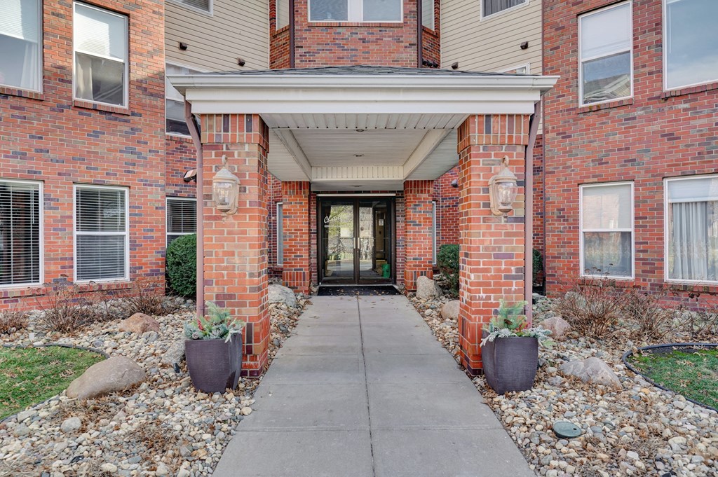 the entrance to a brick building with a sidewalk in front of it
