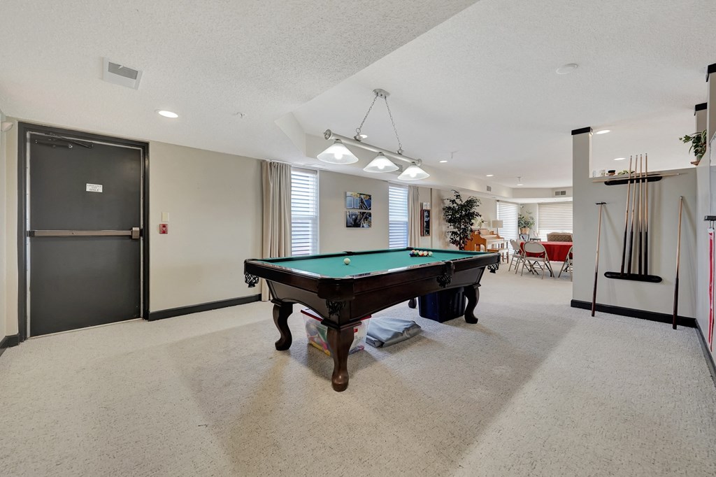 a game room with a pool table in the middle