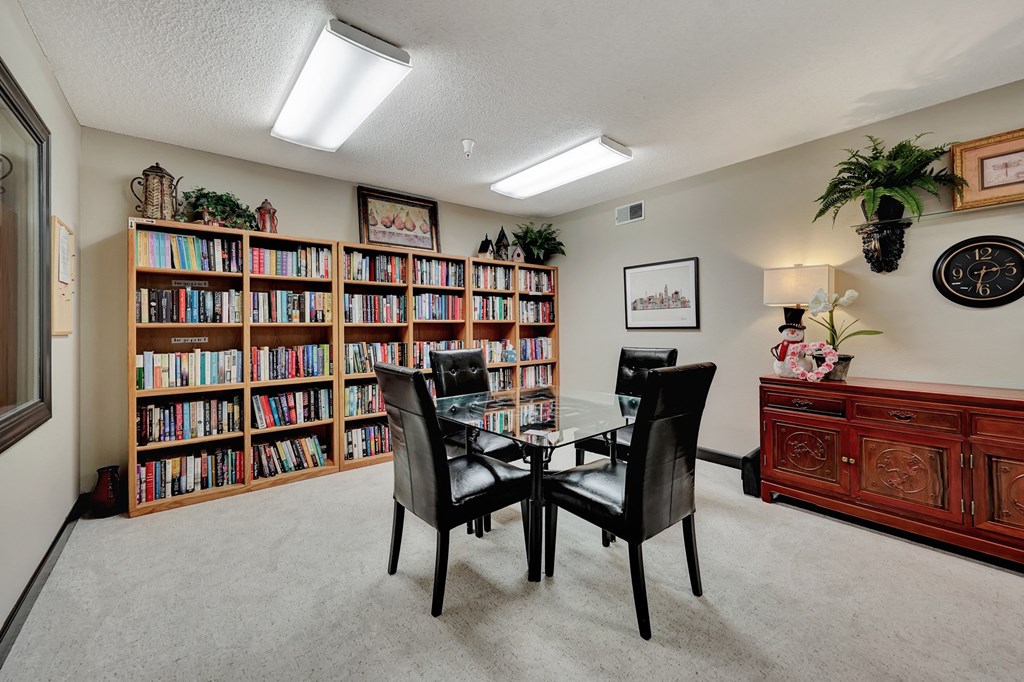 the dining room has plenty of bookshelves and a table with chairs