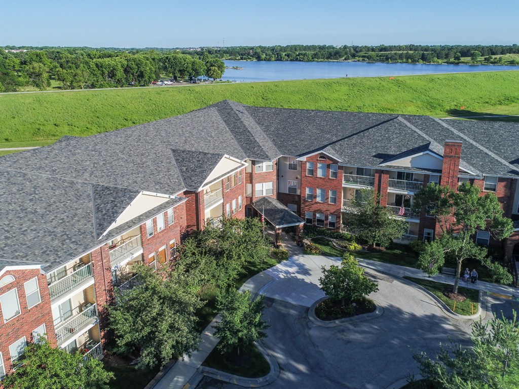 an aerial view of a building with a lake in the background
