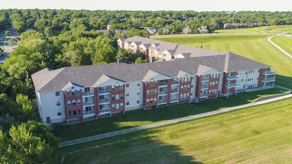 an aerial view of a building surrounded by grass and trees