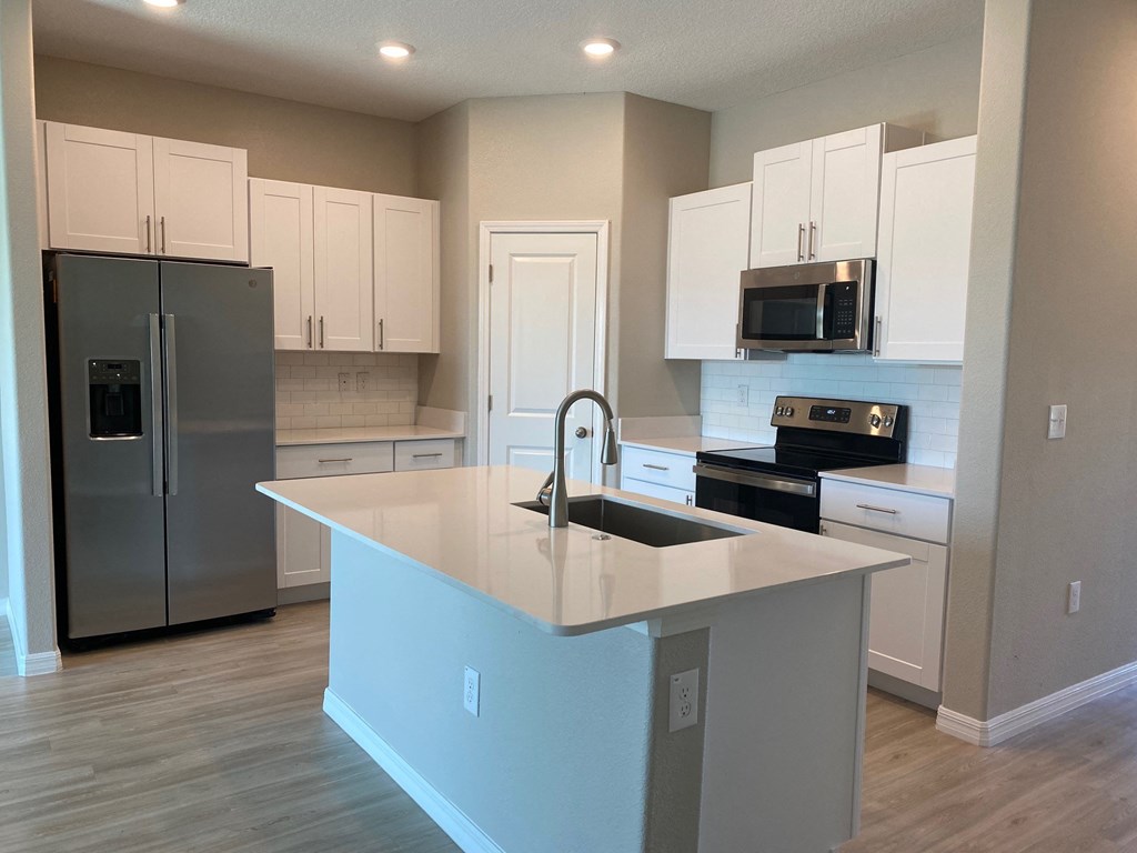 a kitchen with a large island and stainless steel appliances