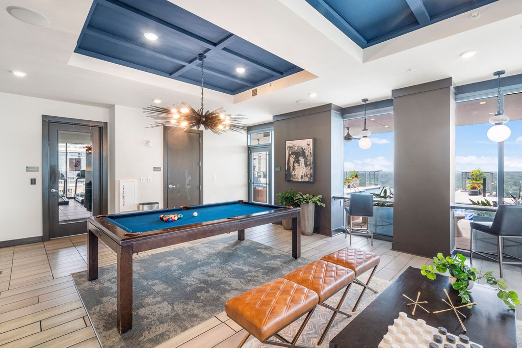 a game room with a pool table and chairs