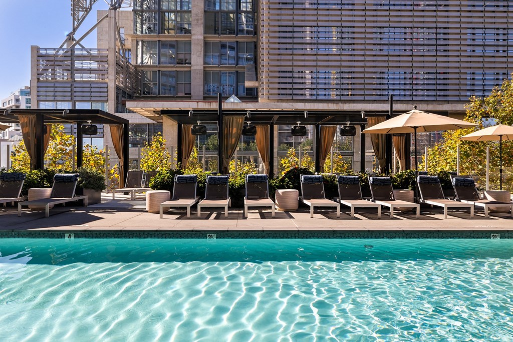 Pool area with lounge chairs at K1 Apartments, California
