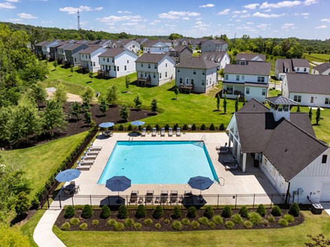 A swimming pool surrounded by a grassy area and a fence.
