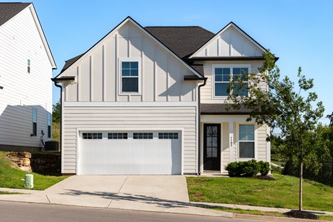 A two-story house with a white garage door.
