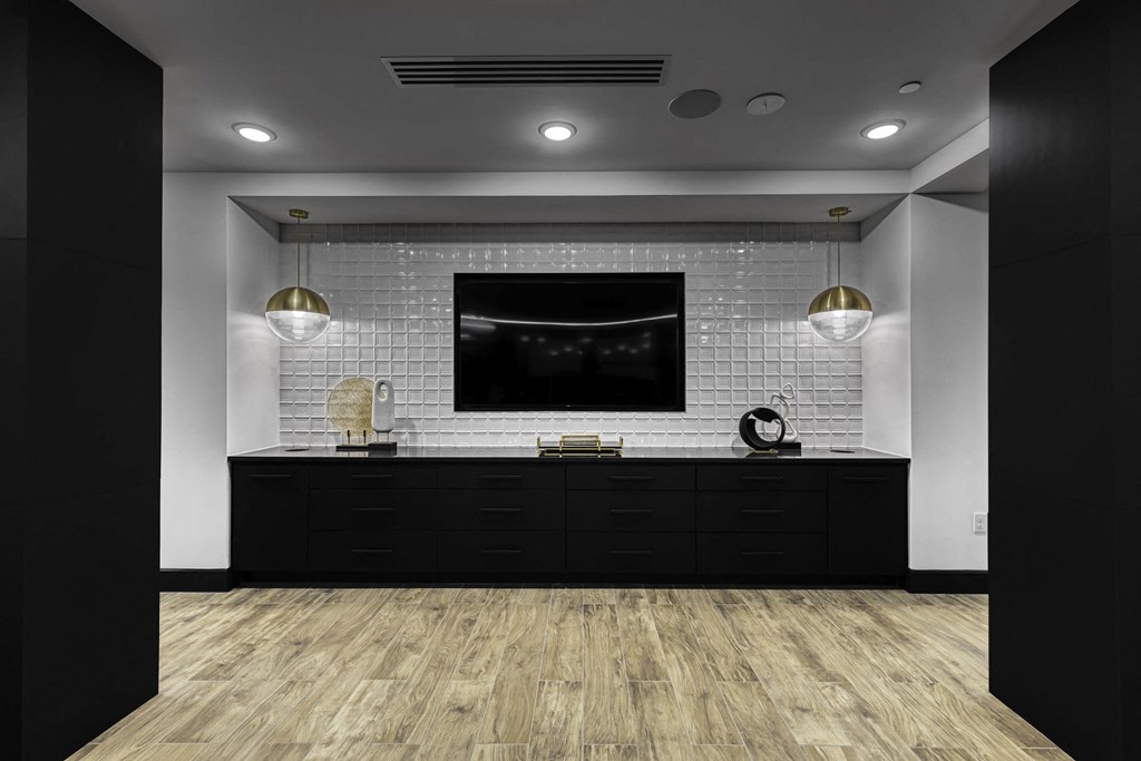 a bathroom with a black vanity and a tv on the wall