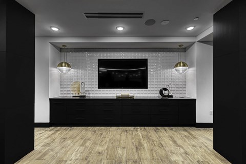 a bathroom with a black vanity and a tv on the wall