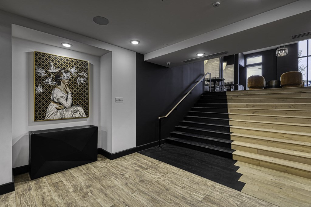 the lobby of a building with stairs and a painting on the wall