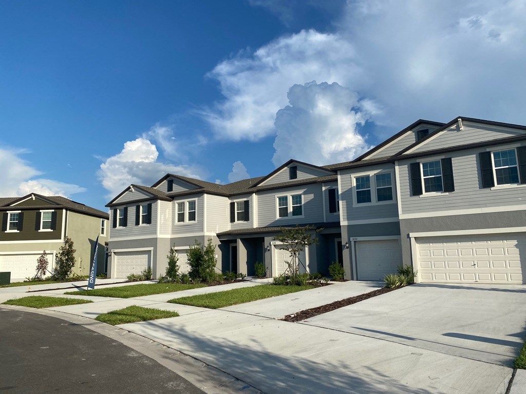 a row of houses on a street with a blue sky