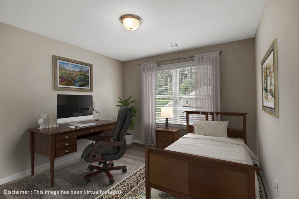 a bedroom with a bed and a desk with a computer