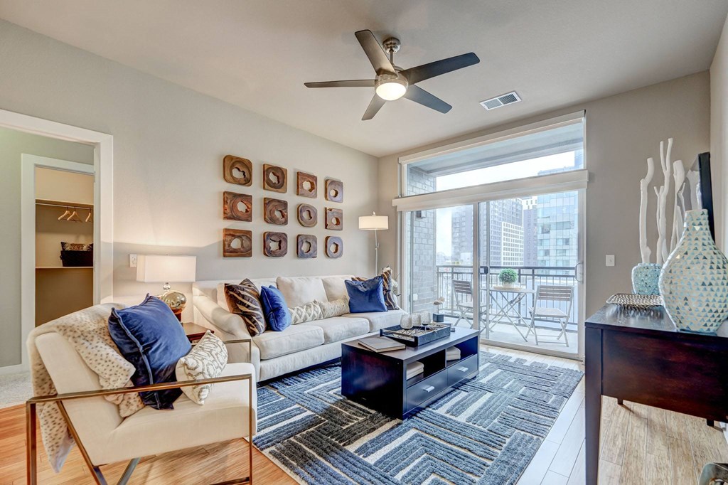 Living room with a large window and a ceiling fan at ALARA Union Station Apartment Homes, Denver, 80202