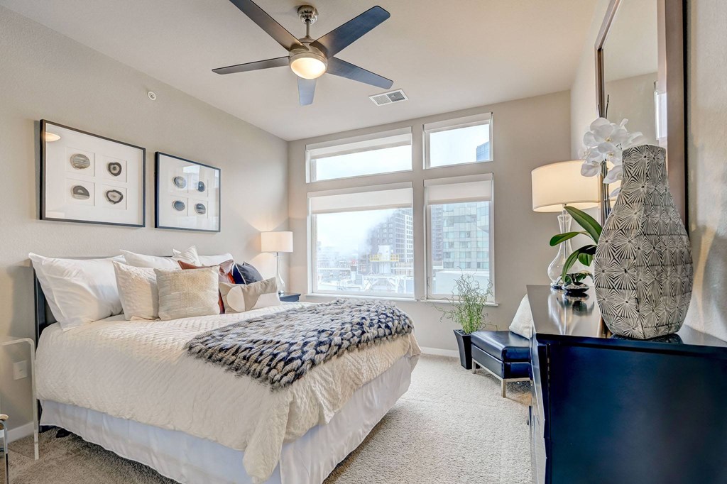 Bedroom with a large window and a ceiling fan at ALARA Union Station Apartment Homes, Denver, 80202