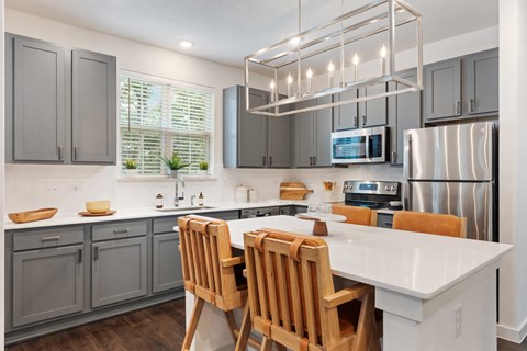a kitchen with a white island and a stainless steel refrigerator