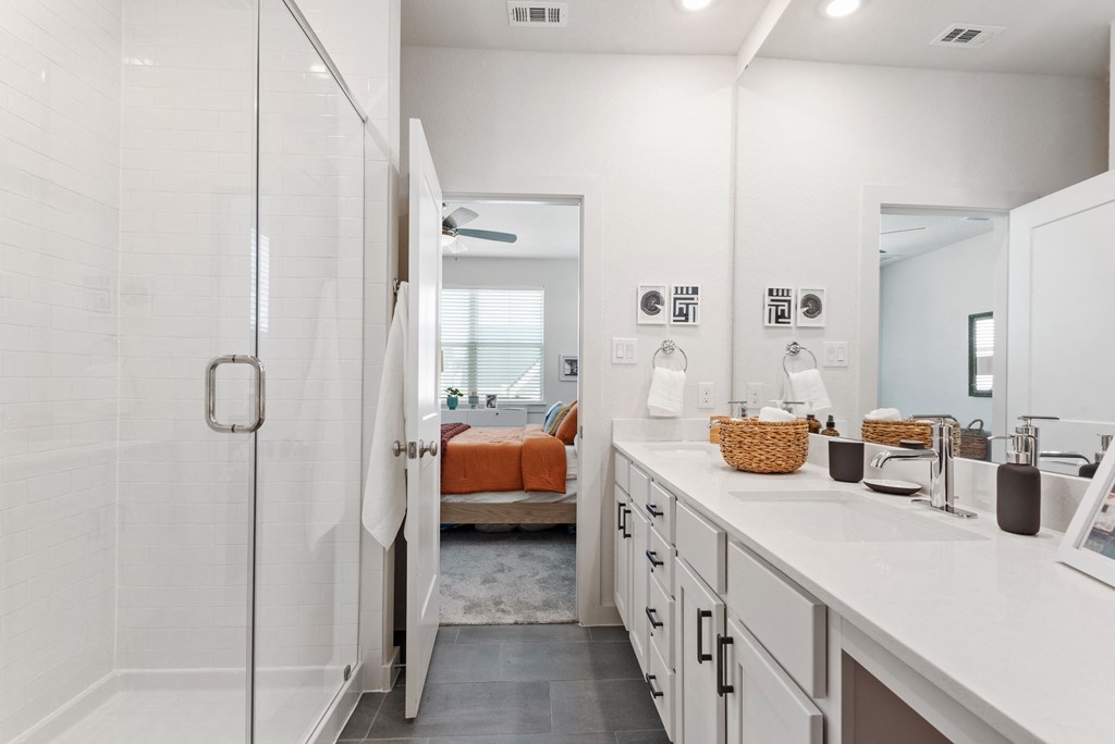 a white bathroom with a shower and a sink
