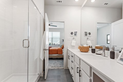 a white bathroom with a shower and a sink