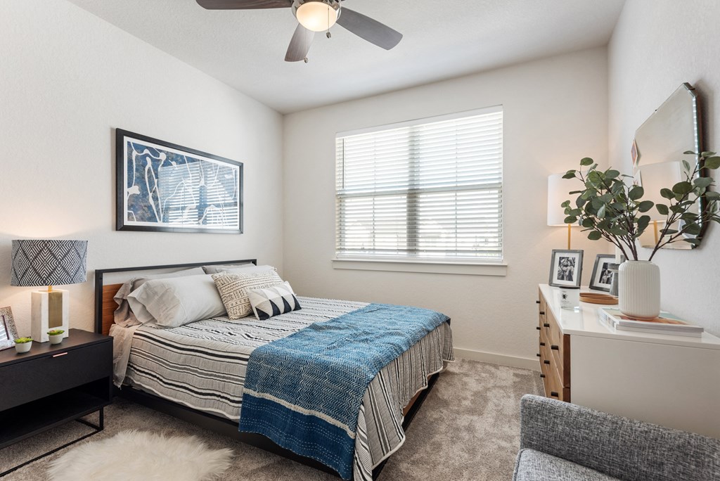 a bedroom with a bed and a ceiling fan