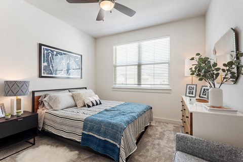 a bedroom with a bed and a ceiling fan