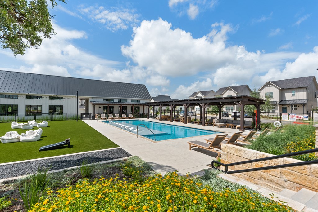 a swimming pool with lounge chairs in front of a building