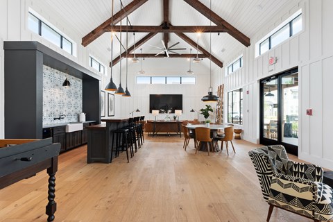 a large living room with a table and chairs and a kitchen with a large window