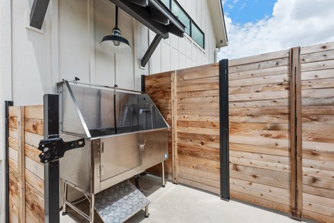 a barbecue grill on a patio next to a wooden fence
