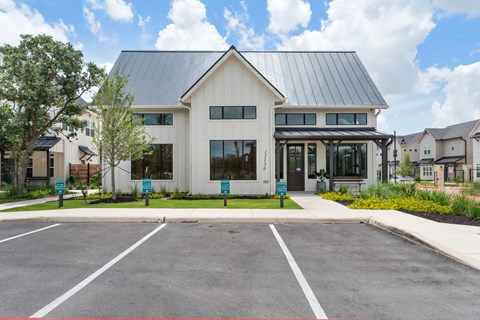 a white house with a parking lot in front of it