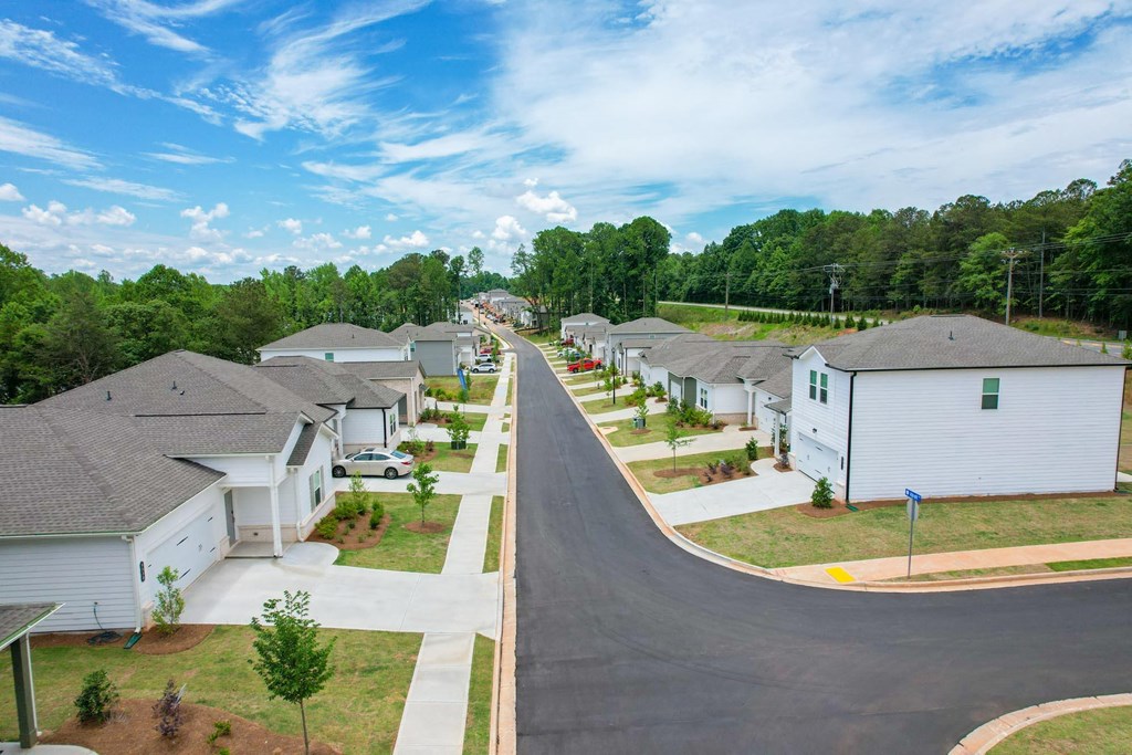 an aerial view of a neighborhood of manufactured homes with trees in the background