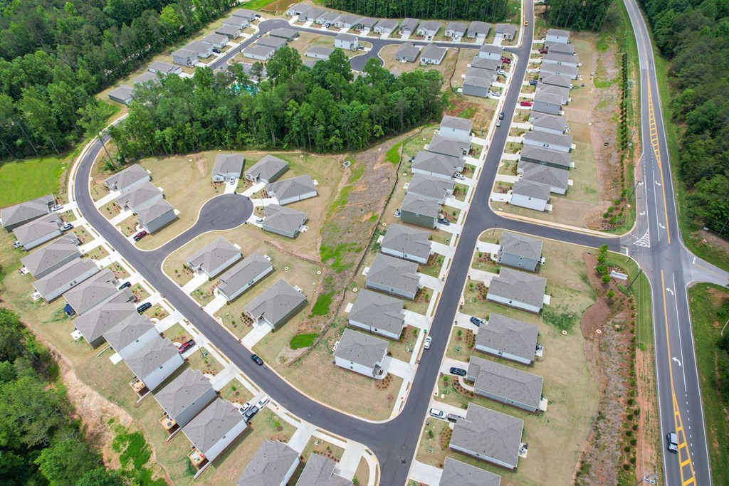 an aerial view of a row of houses with trees in the background