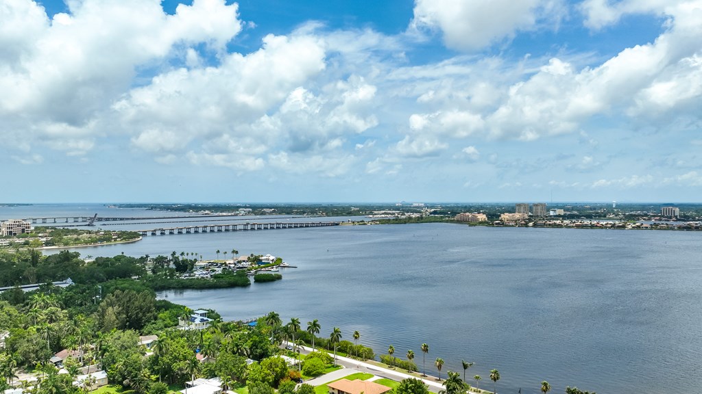 A bridge spans a large body of water with a city in the background.