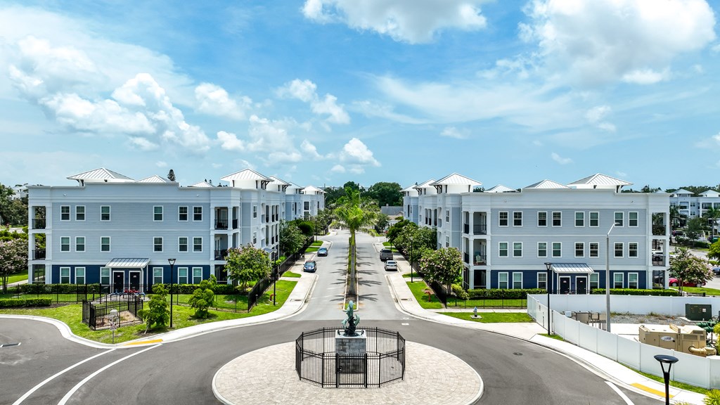 A large white building with a blue sky and white clouds in the background.