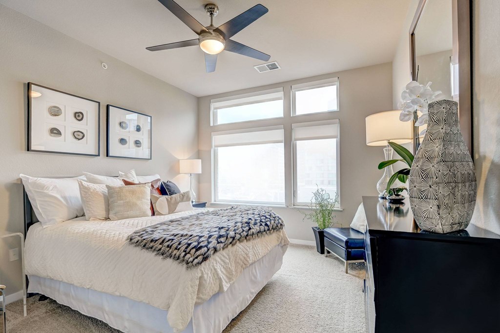 A bedroom with a large bed and a ceiling fan.