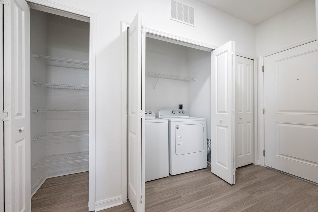 A white laundry room with a washer and dryer.