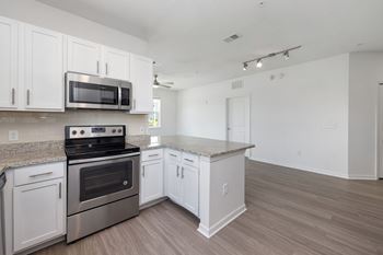 A kitchen with white cabinets and a stainless steel oven.
