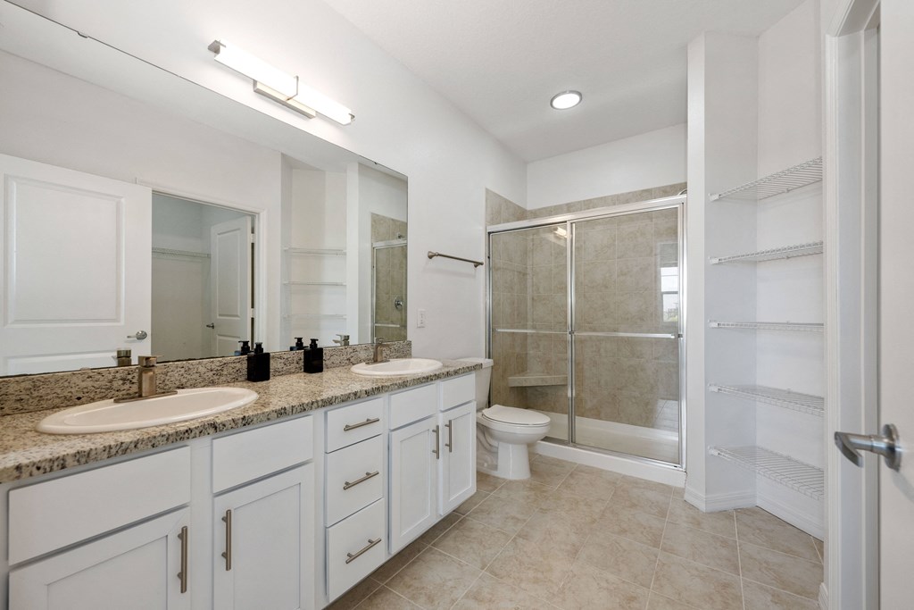 A bathroom with a sink, toilet, and shower.