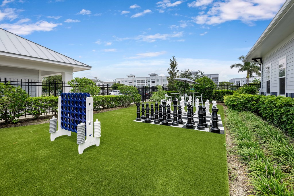 A giant chess set is set up on a lawn.
