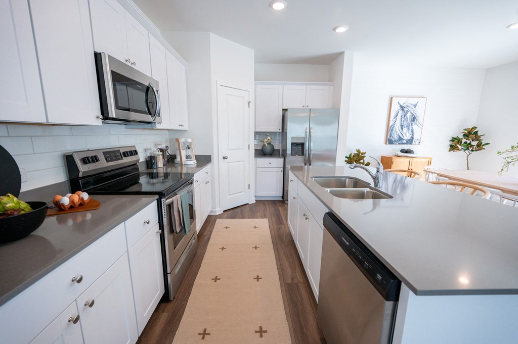 a modern kitchen with stainless steel appliances and white cabinets
