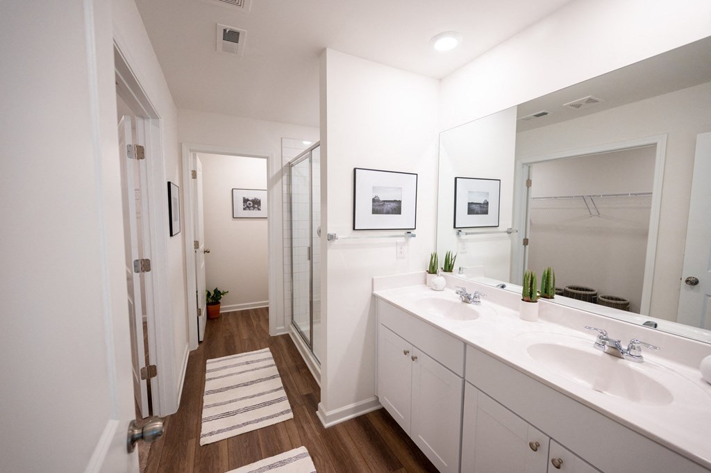 a bathroom with two sinks and a shower and a mirror