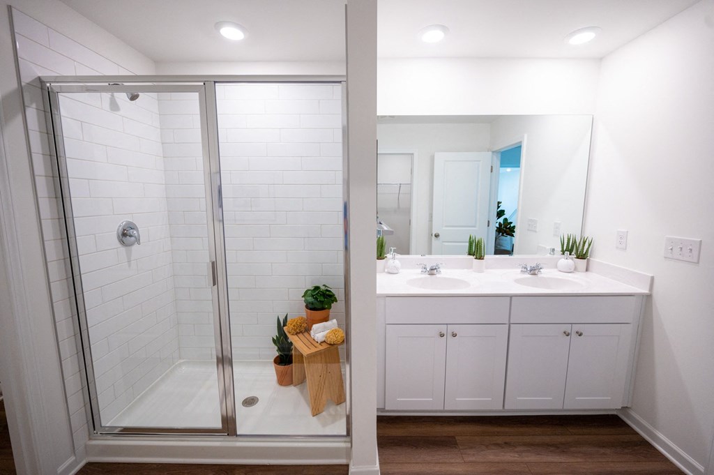 a white bathroom with a shower and a sink