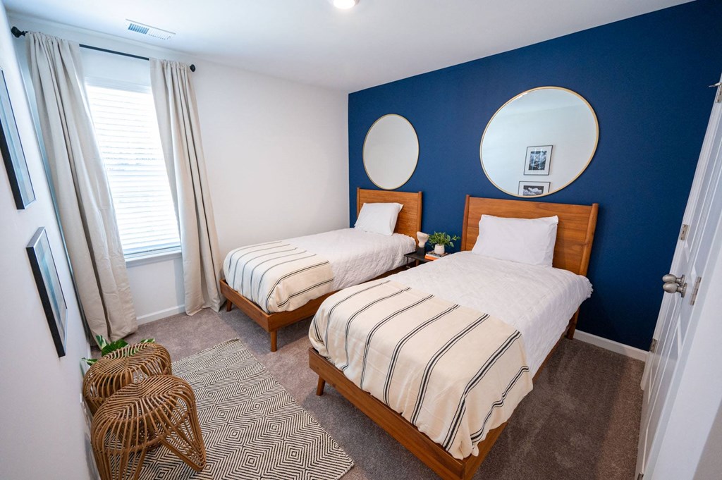 a bedroom with two beds and a blue wall